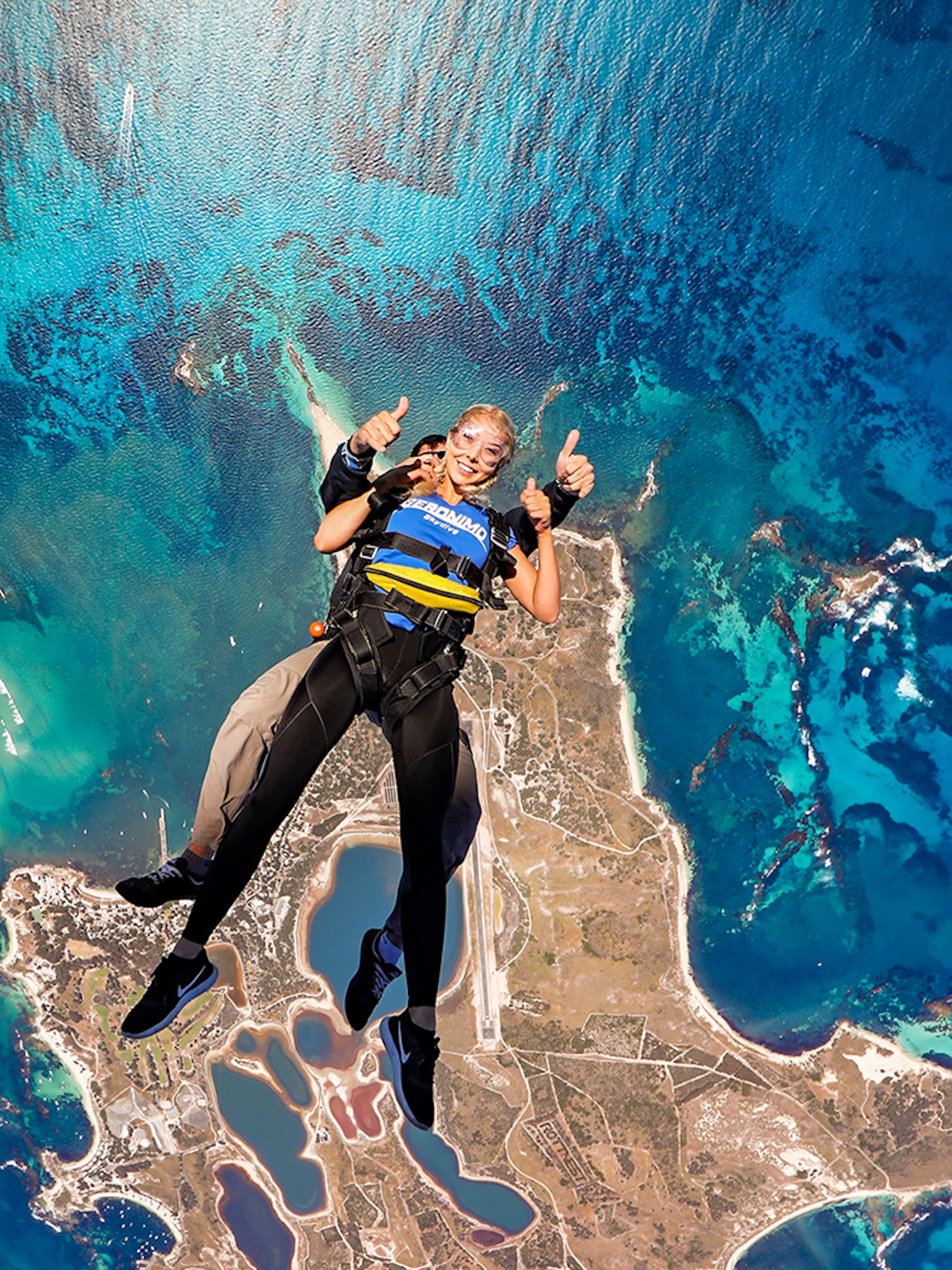 Tandem skydive over Rottnest Island, Perth, with aerial view of coastline and ocean.