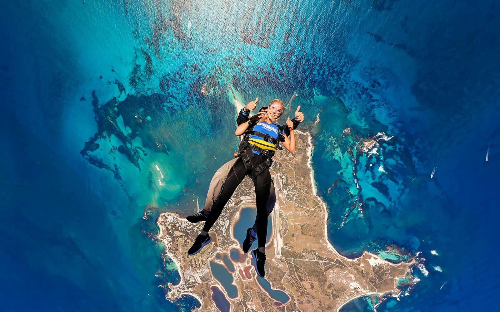 Tandem skydive over Rottnest Island, Perth, with aerial view of coastline and ocean.