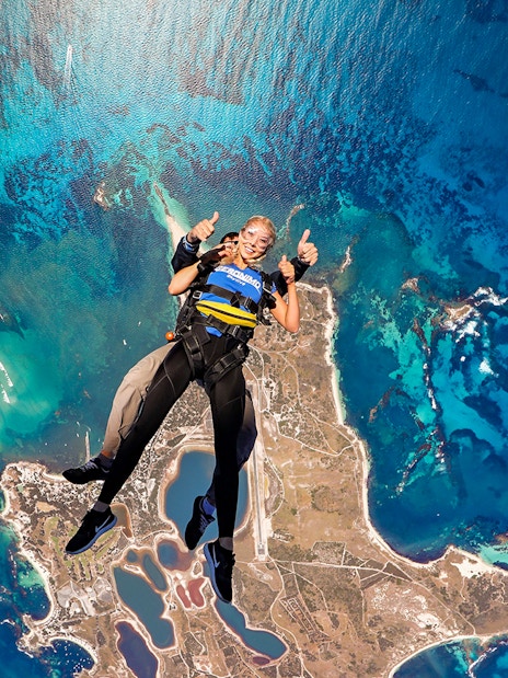 Tandem skydive over Rottnest Island, Perth, with aerial view of coastline and ocean.