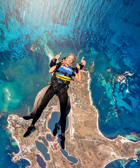 Tandem skydive over Rottnest Island, Perth, with aerial view of coastline and ocean.