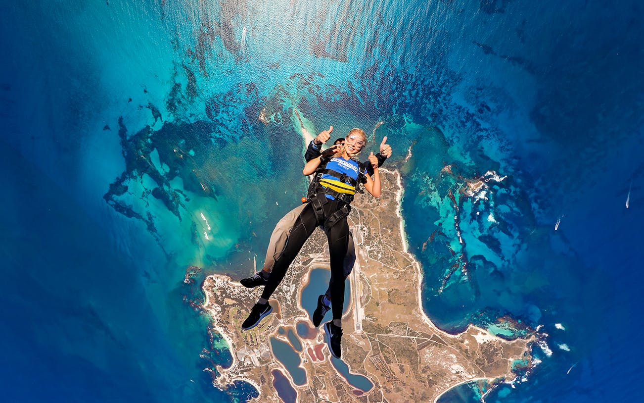 Tandem skydive over Rottnest Island, Perth, with aerial view of coastline and ocean.