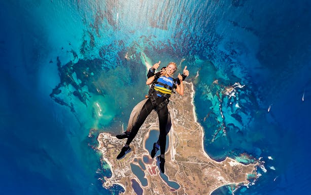Tandem skydive over Rottnest Island, Perth, with aerial view of coastline and ocean.