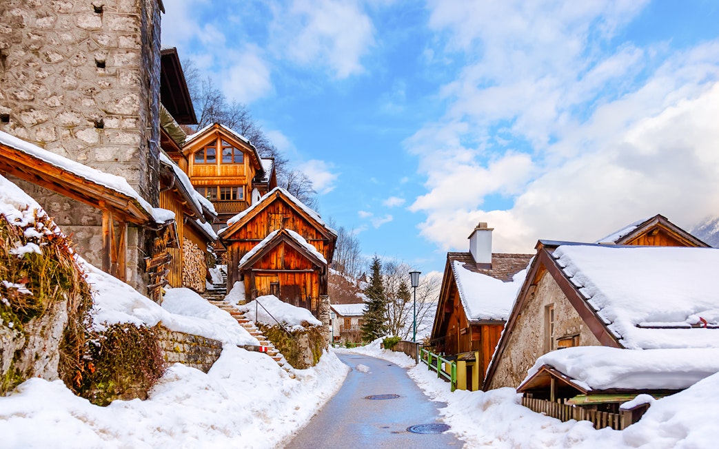 Snow-covered wooden houses in Hallstatt village during winter.
