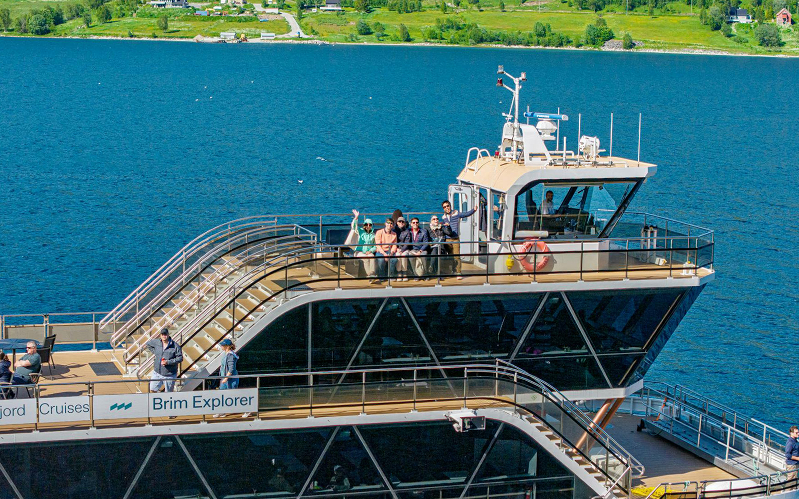 Cruise ship deck with passengers enjoying Arctic fjord views.