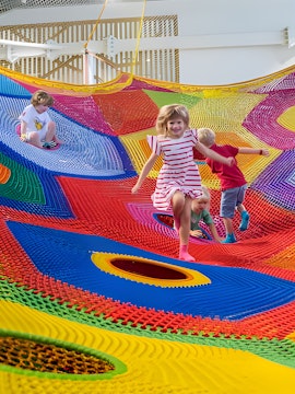 Children playing on colorful nets at Olioli Children's Play Museum, Dubai.