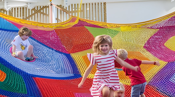 Children playing on colorful nets at Olioli Children's Play Museum, Dubai.