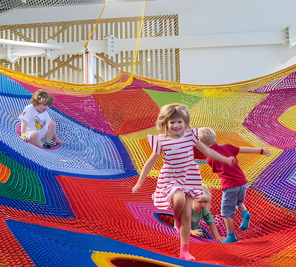 Children playing on colorful nets at Olioli Children's Play Museum, Dubai.