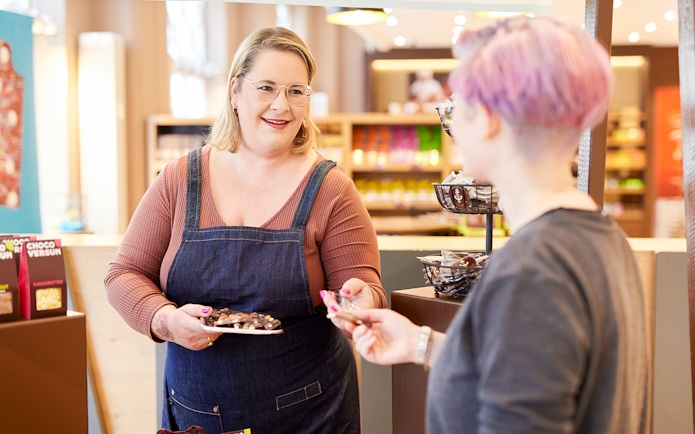 Chocolate tasting experience at Chocoversum, Hamburg with a guide offering samples.