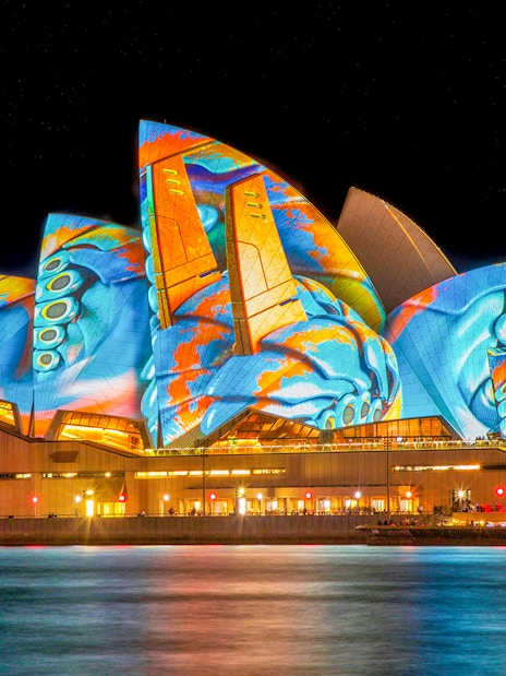 Sydney Opera House illuminated with vibrant Vivid Lights display.