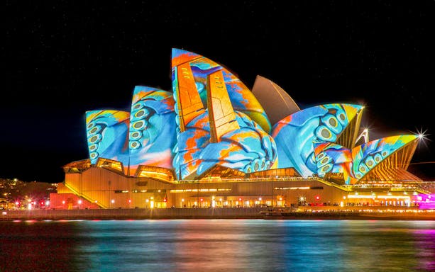 Sydney Opera House illuminated with vibrant Vivid Lights display.