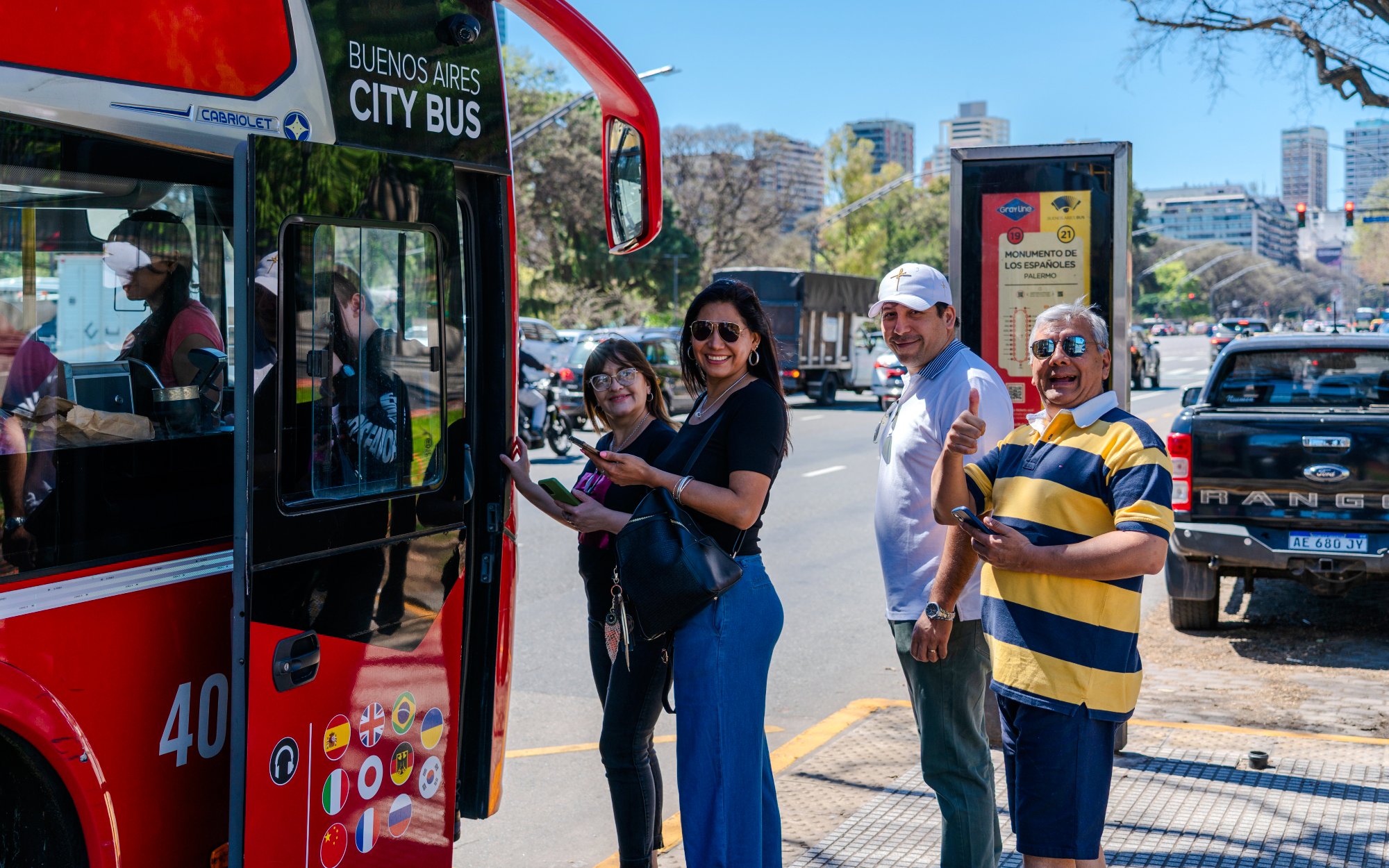 Tourists boarding Buenos Aires Hop-on Hop-off Bus on a sunny street.