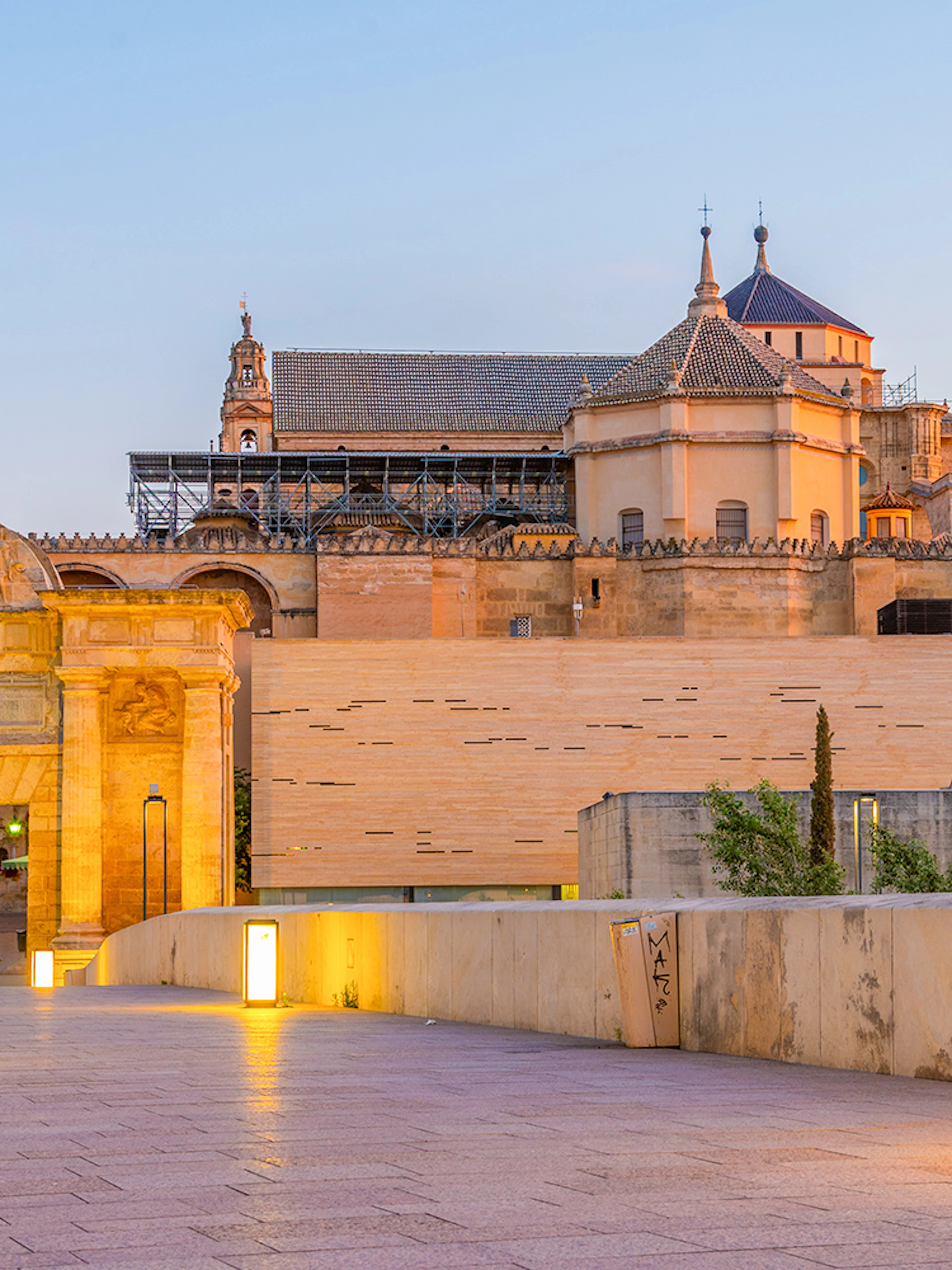 Mezquita de Córdoba exterior view at sunset with illuminated pathway.