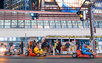 Nighttime go-karting on city streets with illuminated buildings in the background.