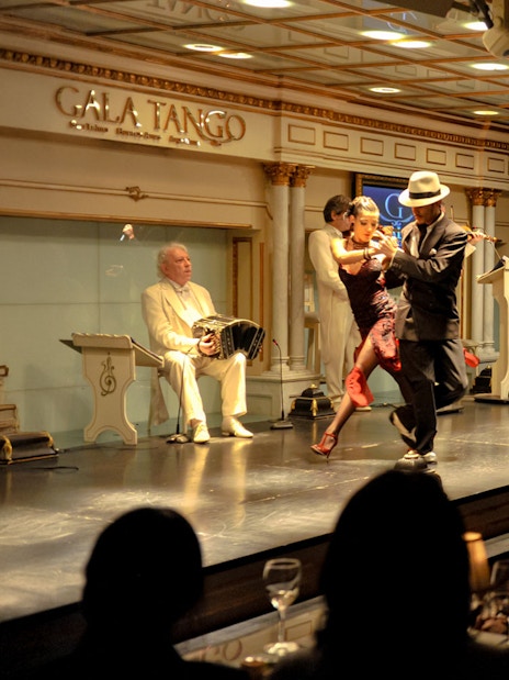 Dancers performing at Gala Tango Show in Buenos Aires with live music.