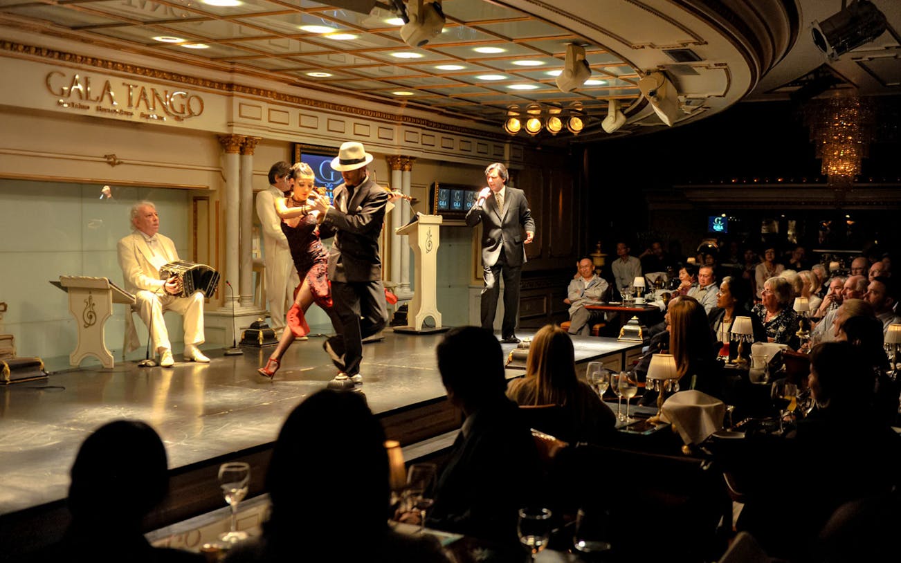 Dancers performing at Gala Tango Show in Buenos Aires with live music.