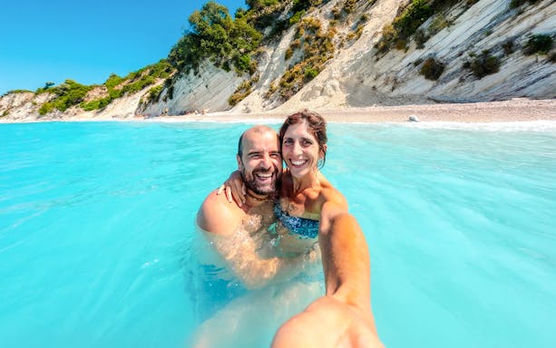 Couple enjoying the water at Gidaki Beach, Ithaca Island, Greece.