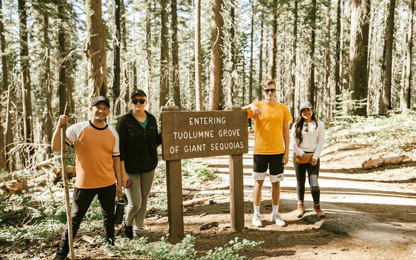 Group at Tuolumne Grove entrance sign in Mariposa Grove Redwoods.