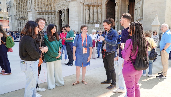 Guide talking with tourists in front of Notre Dame Cathedral, Paris.