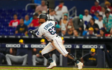 Baseball player in Miami Marlins uniform swinging bat during a game.