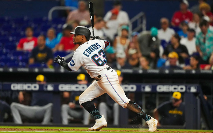 Baseball player in Miami Marlins uniform swinging bat during a game.