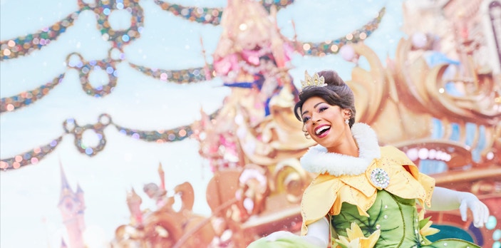 Disneyland Paris Christmas parade with a performer in festive costume.