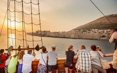 Guests viewing Dubrovnik's city walls on Karaka Ship sunset cruise.