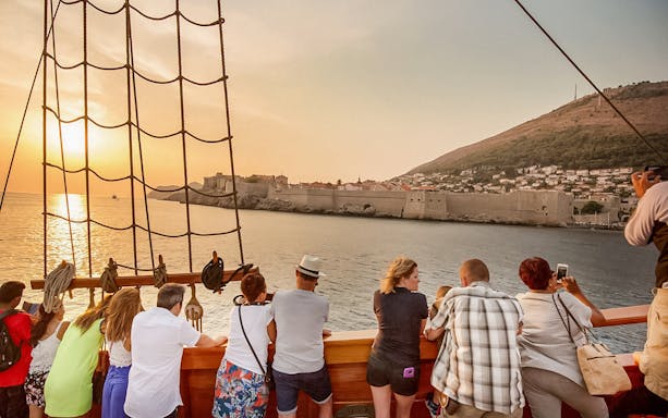 Guests viewing Dubrovnik's city walls on Karaka Ship sunset cruise.