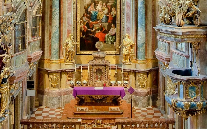Altar and ornate interior of St Anne's Church with religious artwork and statues.