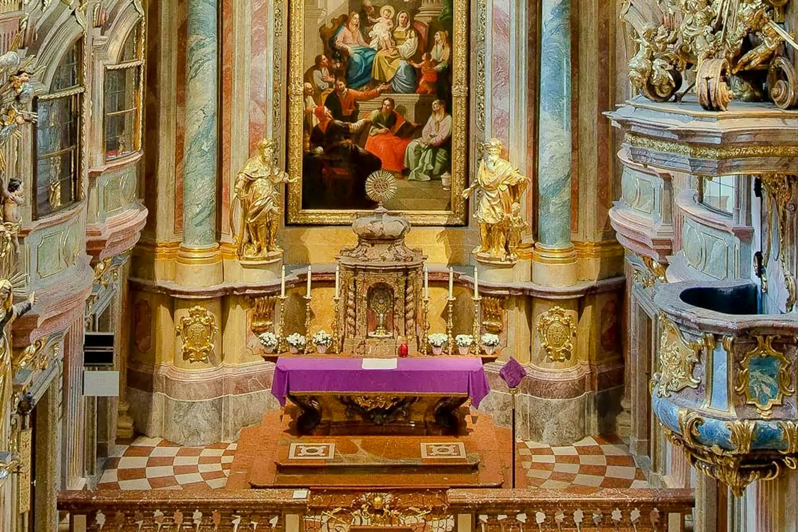 Altar and ornate interior of St Anne's Church with religious artwork and statues.