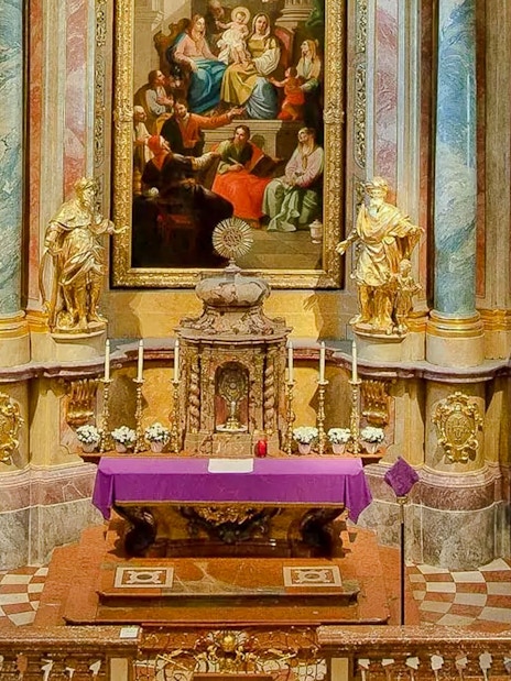 Altar and ornate interior of St Anne's Church with religious artwork and statues.