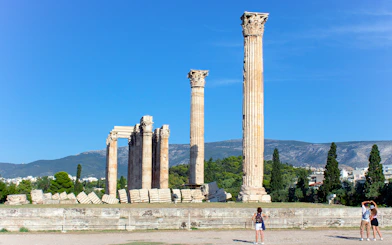 Temple of Olympian Zeus ruins with tourists in Athens, Greece.