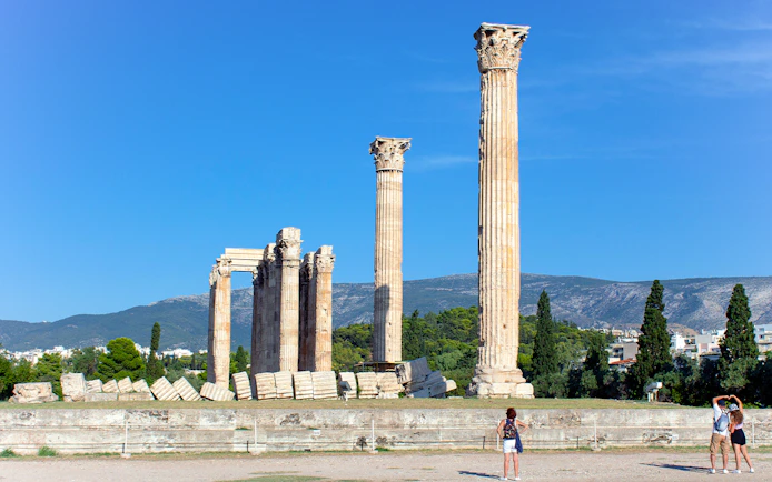 Temple of Olympian Zeus ruins with tourists in Athens, Greece.
