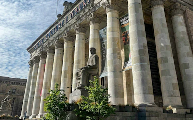 Palace of Culture and Science entrance with columns and statue in Warsaw.