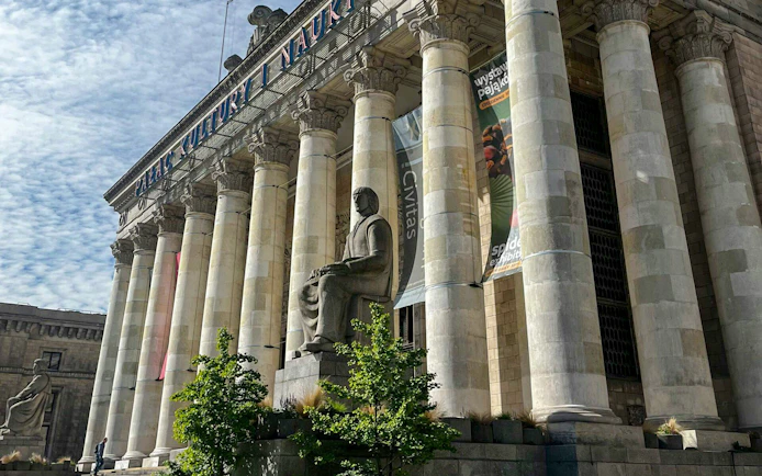 Palace of Culture and Science entrance with columns and statue in Warsaw.
