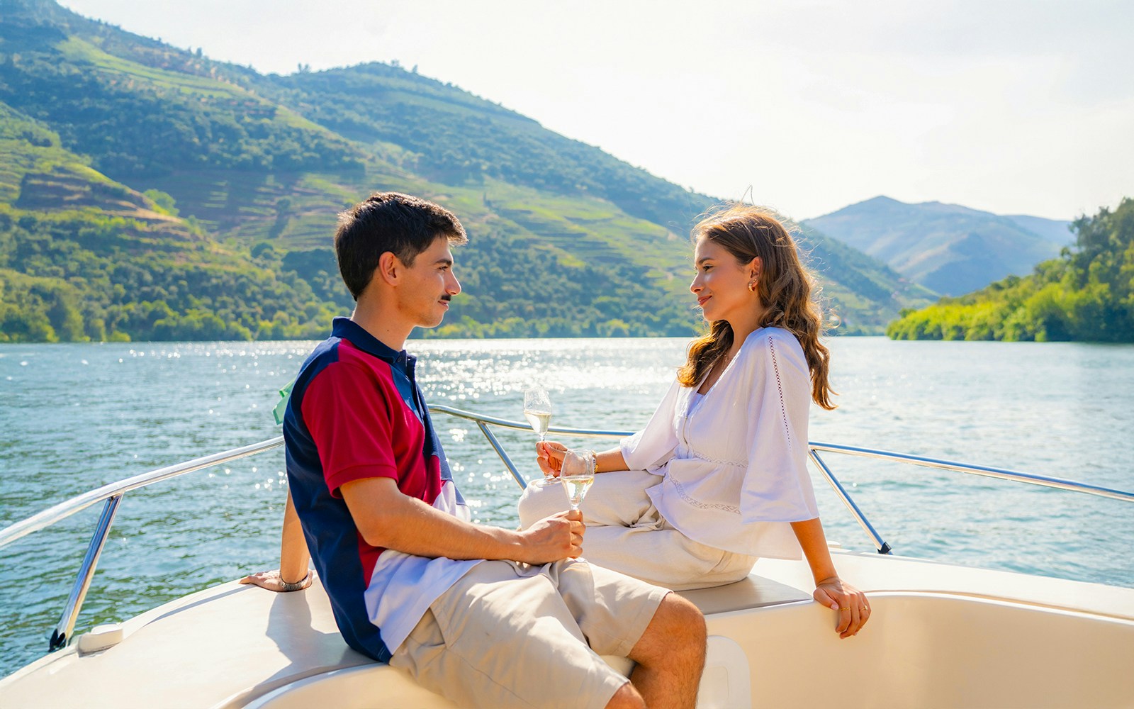 Couple enjoying wine on a boat in Douro Valley tour.