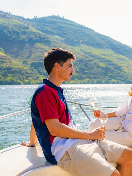 Couple enjoying wine on a boat in Douro Valley tour.