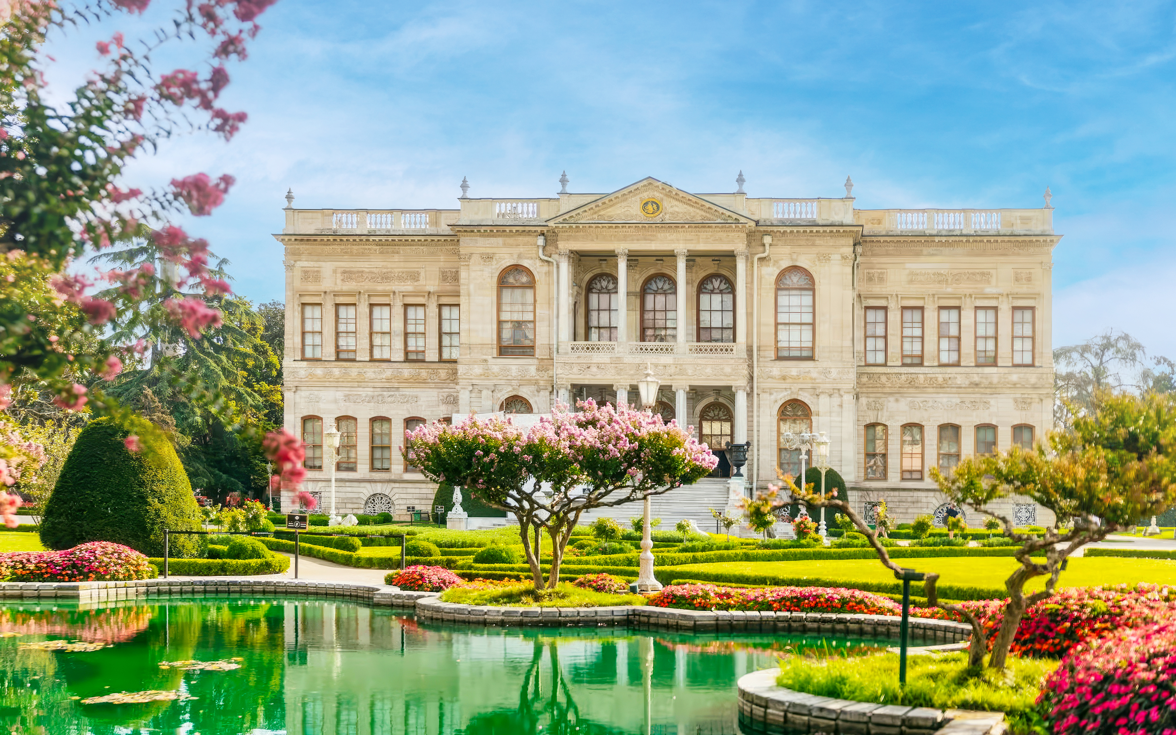 Dolmabahçe Palace facade with gardens and pond in Istanbul, Turkey.