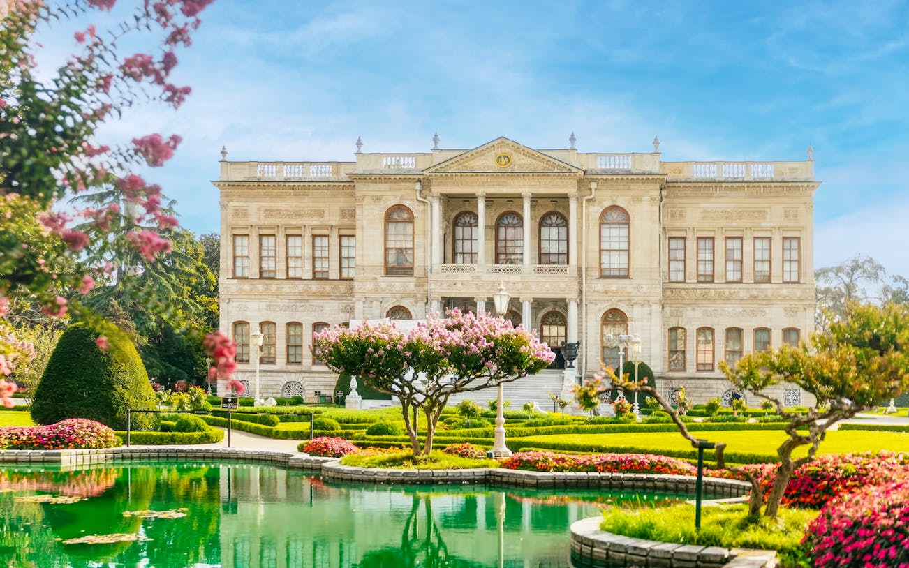Dolmabahçe Palace facade with gardens and pond in Istanbul, Turkey.