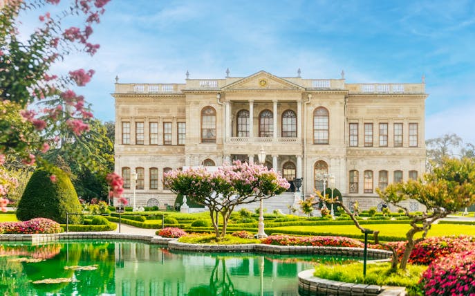 Dolmabahçe Palace facade with gardens and pond in Istanbul, Turkey.