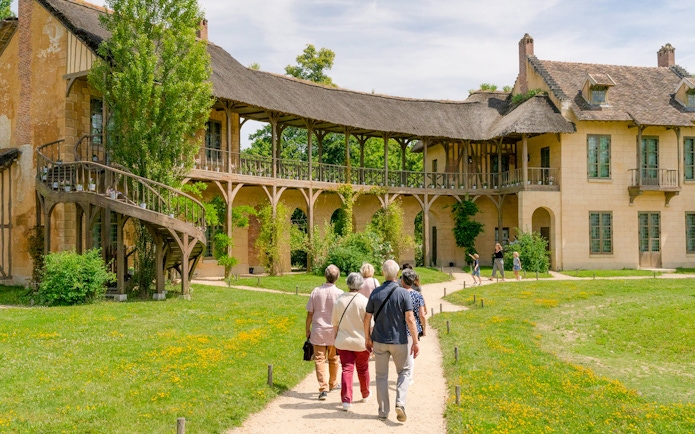 Visitors walking towards the Domain of Marie Antoinette, Palace of Versailles.