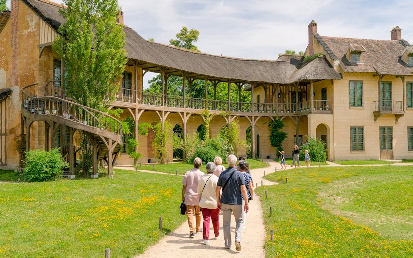 Visitors walking towards the Domain of Marie Antoinette, Palace of Versailles.