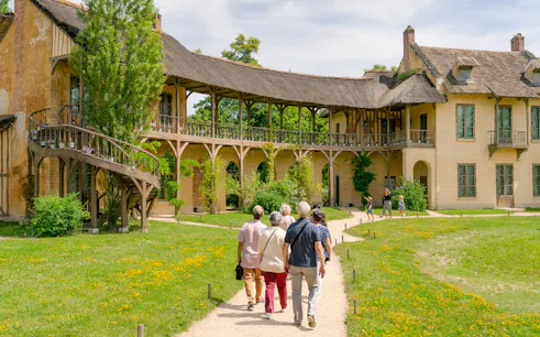 Visitors walking towards the Domain of Marie Antoinette, Palace of Versailles.