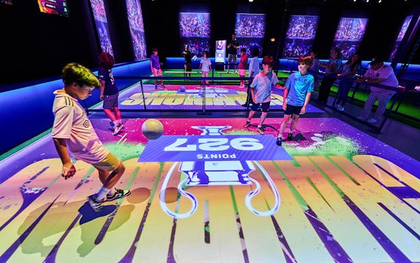 Children playing interactive soccer game at The Messi Experience Dubai.