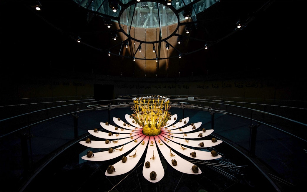 Expo City Dubai installation with illuminated flower sculpture under a glass dome.
