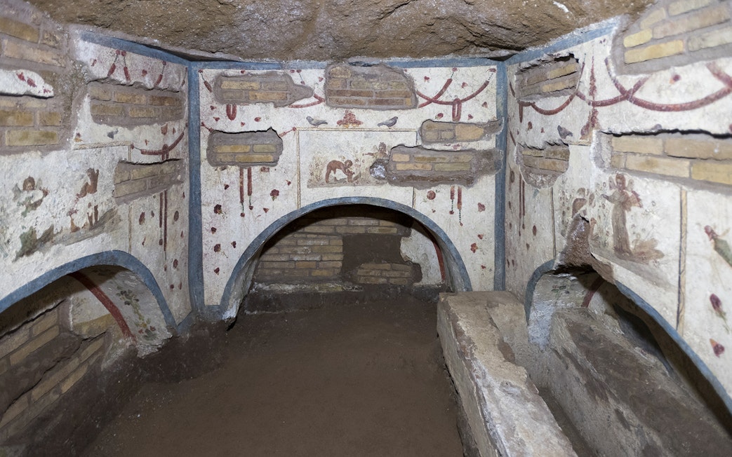 Catacombs of Domitilla in Rome with ancient frescoes and burial niches.