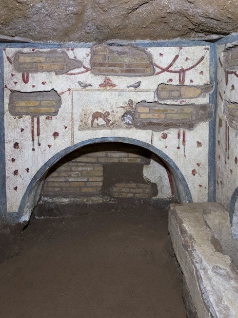 Catacombs of Domitilla in Rome with ancient frescoes and burial niches.