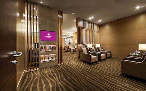 Plaza Premium Lounge seating area with armchairs and magazines.