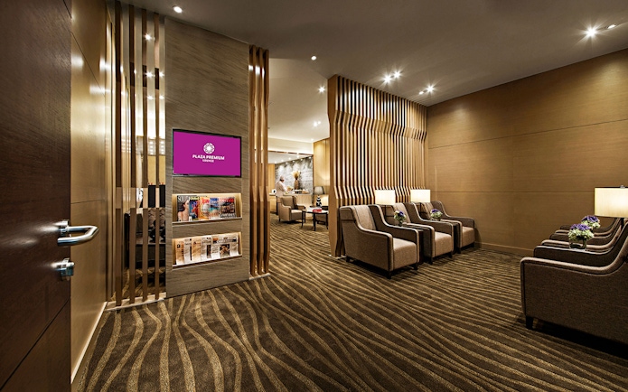 Plaza Premium Lounge seating area with armchairs and magazines.