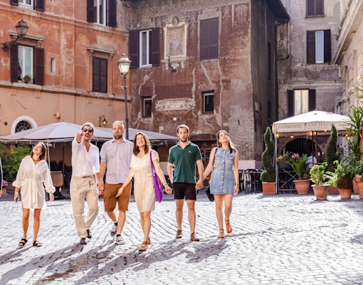 Group walking through a historic square in Rome on a guided food tour.