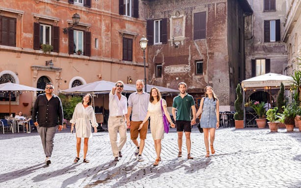Group walking through a historic square in Rome on a guided food tour.